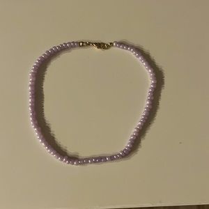 Purple choker with a gold clasp. Not very tight on the neck and can be adjusted.